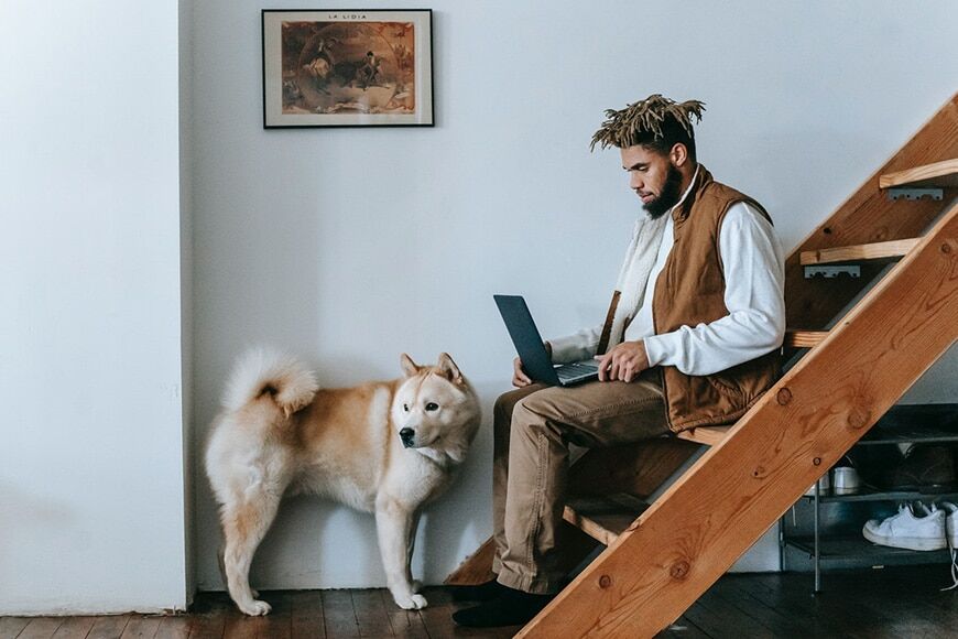 Man op laptop met hond